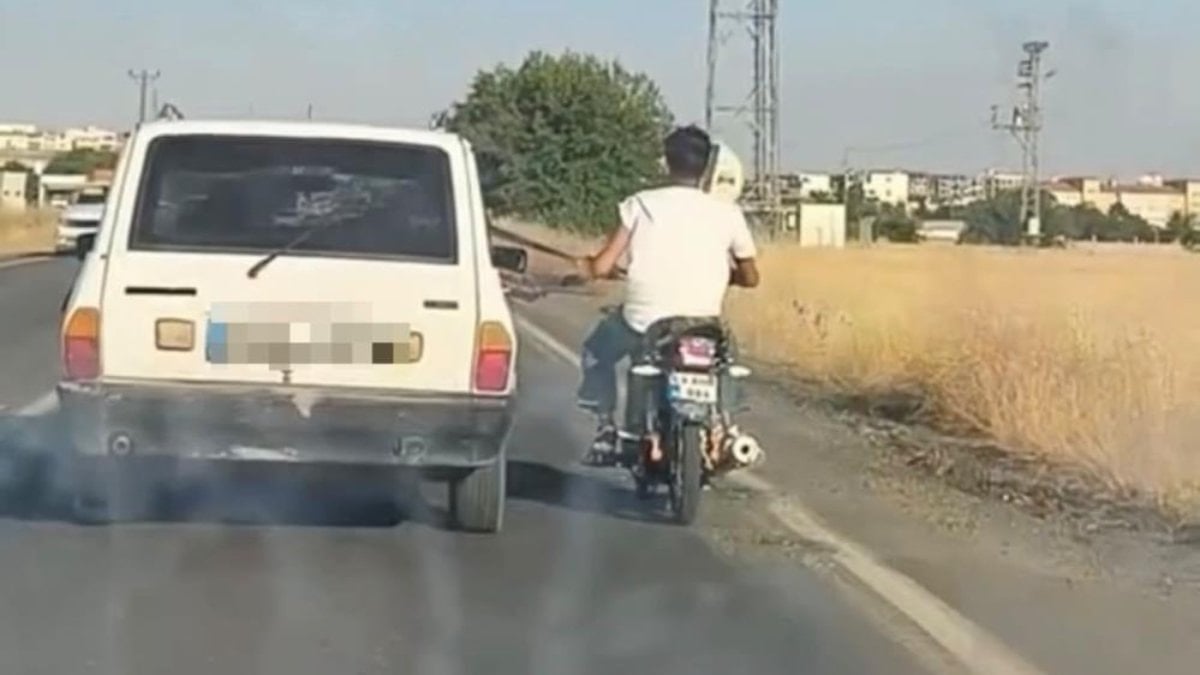 Şanlıurfa'da motosiklet sürücüsü, otomobile tutunarak yol aldı